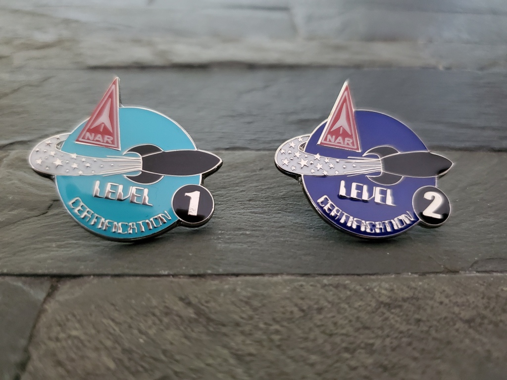 close up of metal badges that say level 1 and level 2 certification