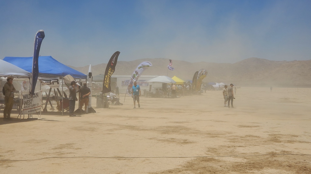 dust storms from strong winds in the desert, with people and tents partially visible